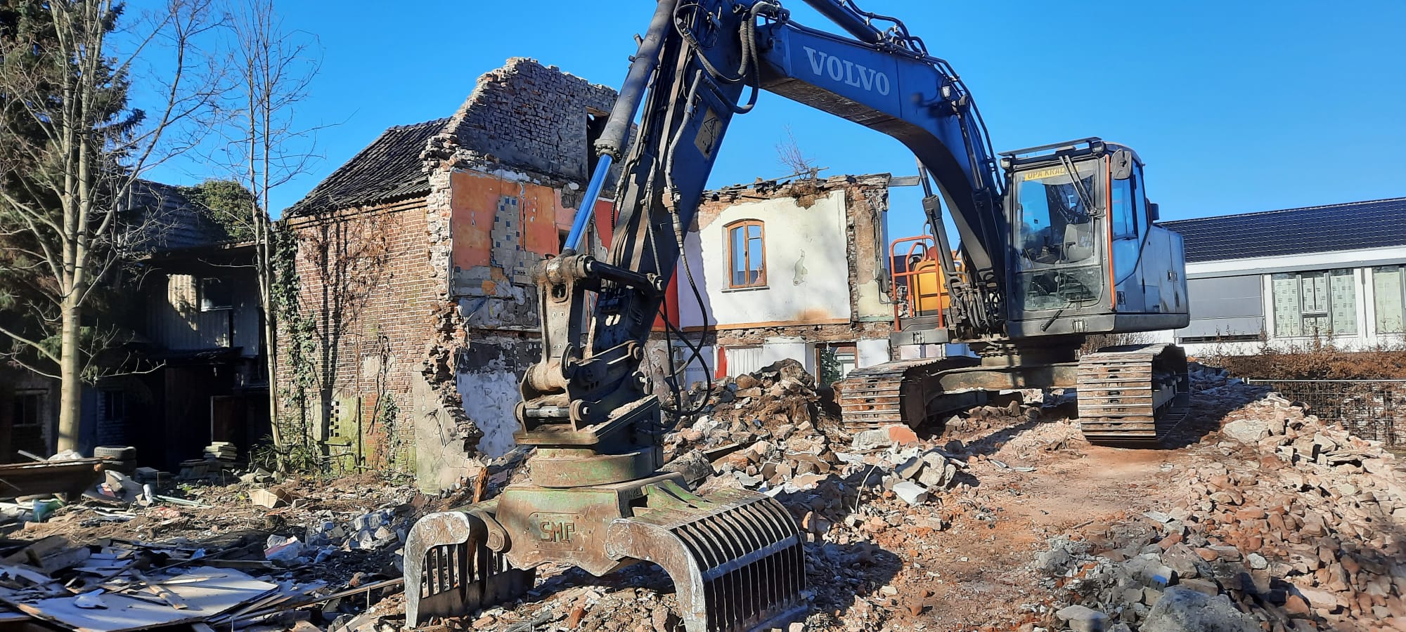 Abbruchbagger von BERK Recycling mit Sortiergreifer beim Rückbau eines Wohnhauses